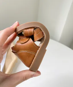Détail de sandales souples en cuir marron pour bébé montrant une semelle très flexible