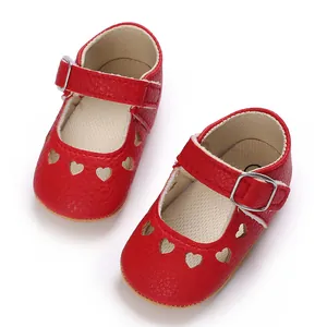 Close-up view of red baby princess shoes with heart-shaped cutouts and adjustable buckle strap.