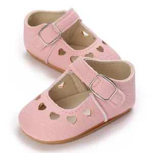 Close-up of pink baby princess shoes with cute heart cutouts and rubber sole.