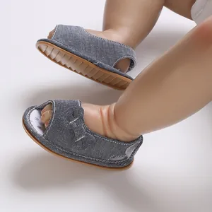 Nahaufnahme von atmungsaktiven Babysandalen mit Schleife und weicher rutschfester Sohle.
