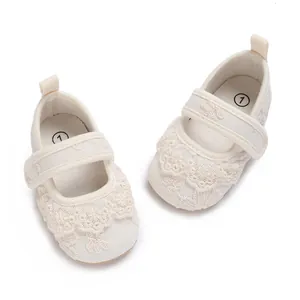 Detalle de zapatos de princesa para bebé de encaje blanco con suelas suaves y antideslizantes