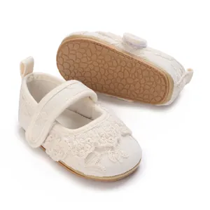 Detalle de zapatos de princesa de encaje blanco para bebé con suela de goma suave antideslizante.