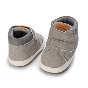 Nahaufnahme graue strukturierte Lauflernschuhe für Babys mit doppeltem Klettverschluss