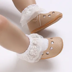 Close-up view of baby princess shoes featuring heart cutouts and delicate white lace trim