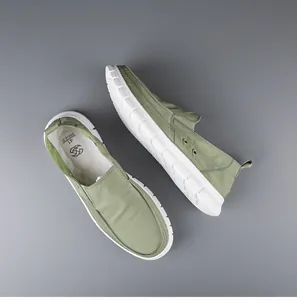 Top view detail of green breathable canvas slip-on loafers with soft white soles