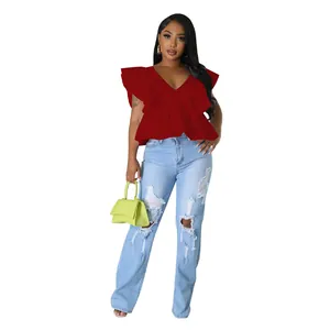 Ganzkörperansicht des Models in rotem V-Ausschnitt Rüschenärmel-Top und Jeans