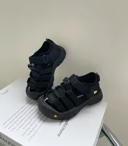 Détail de sandales de sport noires pour enfants avec un embout de protection jaune