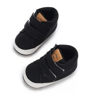 Nahaufnahme von schwarzen Kleinkinderschuhen mit Klettverschluss und weißen Anti-Rutsch-Sohlen