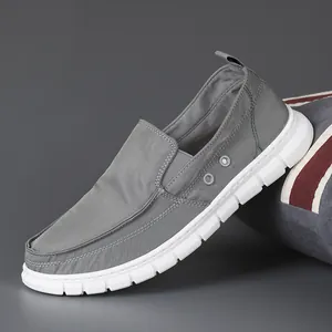 Grey slip-on canvas loafers for men featuring breathable fabric and soft white soles.
