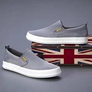 Pair of breathable grey mesh slip-on loafers for men featuring white soles and side tags