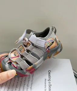 Détail de sandales de sport pour enfants avec imprimé graffiti coloré et fermeture velcro.
