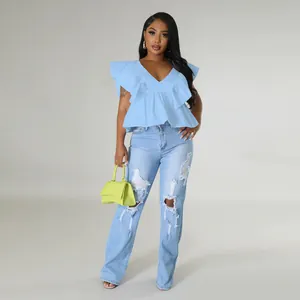 Detailansicht eines hellblauen V-Ausschnitt-Oberteils mit Rüschen und Distressed-Jeans