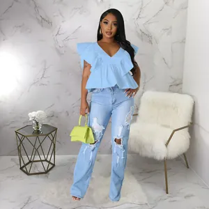 Ganzkörperansicht eines Models in hellblauem Rüschentop mit V-Ausschnitt und Destroyed-Jeans