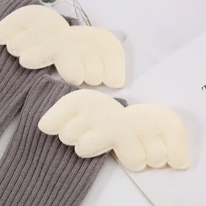 Close-up detail of soft plush angel wings on grey ribbed baby mid-calf socks