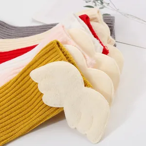 Detailed view of baby ribbed knit socks featuring soft plush 3D angel wings decoration