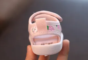 Gros plan sur le talon de la sandale rose pour bébé avec motifs fraise et ours