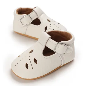 Nahaufnahme weißer Baby-T-Strap-Schuhe mit weichen, rutschfesten Sohlen und Lochmuster