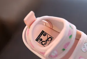 Vue détaillée de la semelle rose douce et des motifs d'une sandale de marche pour bébé.