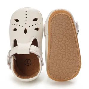 Nahaufnahme von Babyschuhen mit Lochmustern und rutschfester Sohle mit Kieselstein-Struktur.