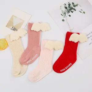 Detail view of colorful ribbed baby socks with cute 3D angel wings and anti-slip soles