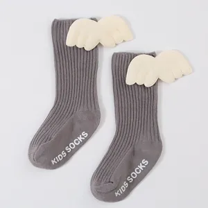 Detail view of grey ribbed baby socks with 3D angel wings and non-slip sole text.