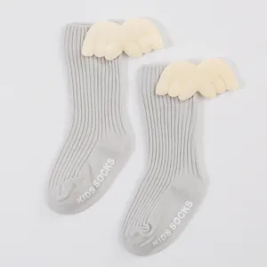 Detailed view of grey ribbed baby socks with cream angel wings and anti-slip sole lettering