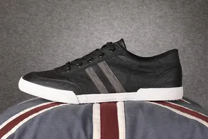Detailed side view of men's black and white low-top casual sneakers with stripes