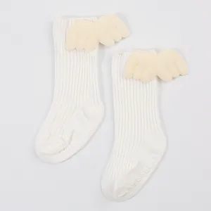 Detailed view of cream baby ribbed mid-calf socks with cute 3D plush wing decorations.