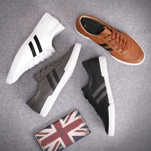 Top-down macro view of four men's low-top color-block sneakers in white, brown, grey, and black