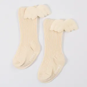 Detail of cream baby ribbed socks featuring 3D angel wings and anti-slip soles