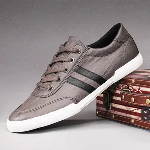 Stylish men's grey low-top breathable sneakers with black stripes and white rubber sole