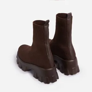 Macro view of dark brown breathable knit sock boots featuring a thick lugged platform sole.