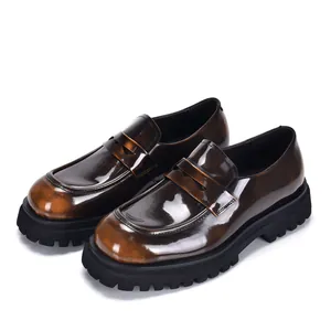 Gedetailleerde weergave van bruine lakleren platform loafers voor heren met een dikke zwarte zool