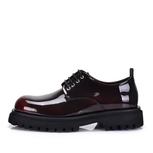 Side view of shiny burgundy leather derby shoes with thick black rubber lug sole