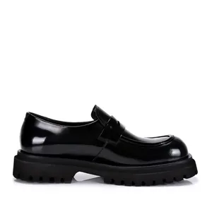 Gedetailleerd zijaanzicht van zwarte chunky platform loafers in glanzend leer