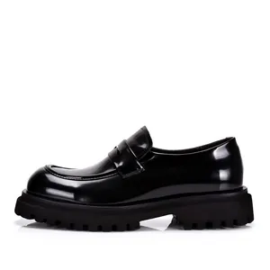Gedetailleerd zijaanzicht van een luxe zwarte laklederen loafer met een dikke profielzool