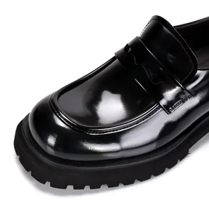 Gedetailleerd zijaanzicht van de glanzende zwarte laklederen chunky heren loafers