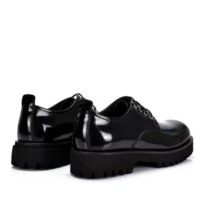 Detailed rear view of black glossy genuine leather Derby shoes with chunky platform sole