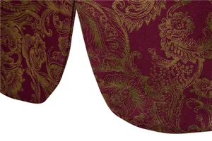 Dettaglio macro del tessuto della giacca bordeaux con motivo floreale paisley dorato