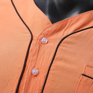 Detail view of orange men's thin nightgown with black piping and transparent buttons