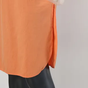 Detailed macro view of side slit and curved hem on lightweight orange men's sleepwear robe