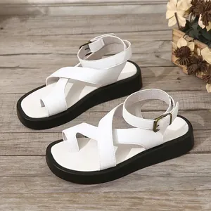 Gedetailleerde weergave van witte plateausandalen met kruisbanden en gespdetails uitgelicht.