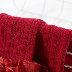 Detailed close-up of dark red ribbed knit fabric and lace trim on baby princess socks.