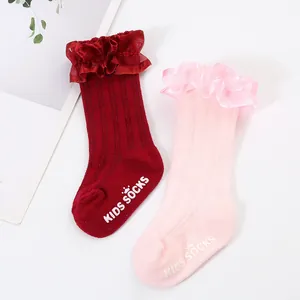 Close-up of ribbed kids socks with ruffled organza lace trim and anti-slip grips