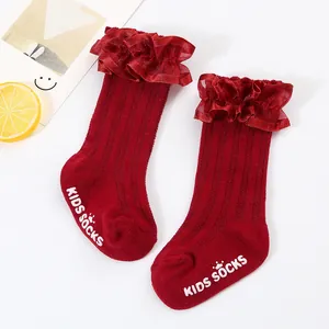 Detailed view of red children's ruffle socks featuring white anti-slip dots on sole.