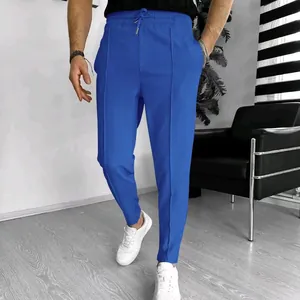 Detailed view of men's blue waffle knit casual pants featuring drawstring waist and seam.