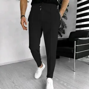 Detail view of men's black waffle knit trousers showing texture and drawstring.