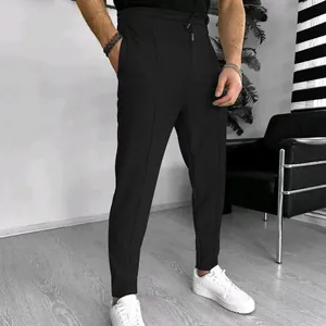 Men's black waffle textured drawstring casual pants with minimalist design style.