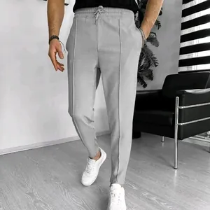 Men's waffle texture casual drawstring trousers in light grey shown in a modern interior