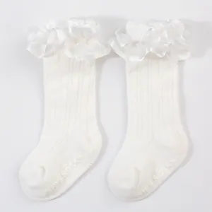 Detailed view of white ruffled baby princess socks with anti-slip grip on bottom